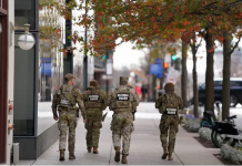 US halts asylum decisions as troop killing sparks migrant crackdown